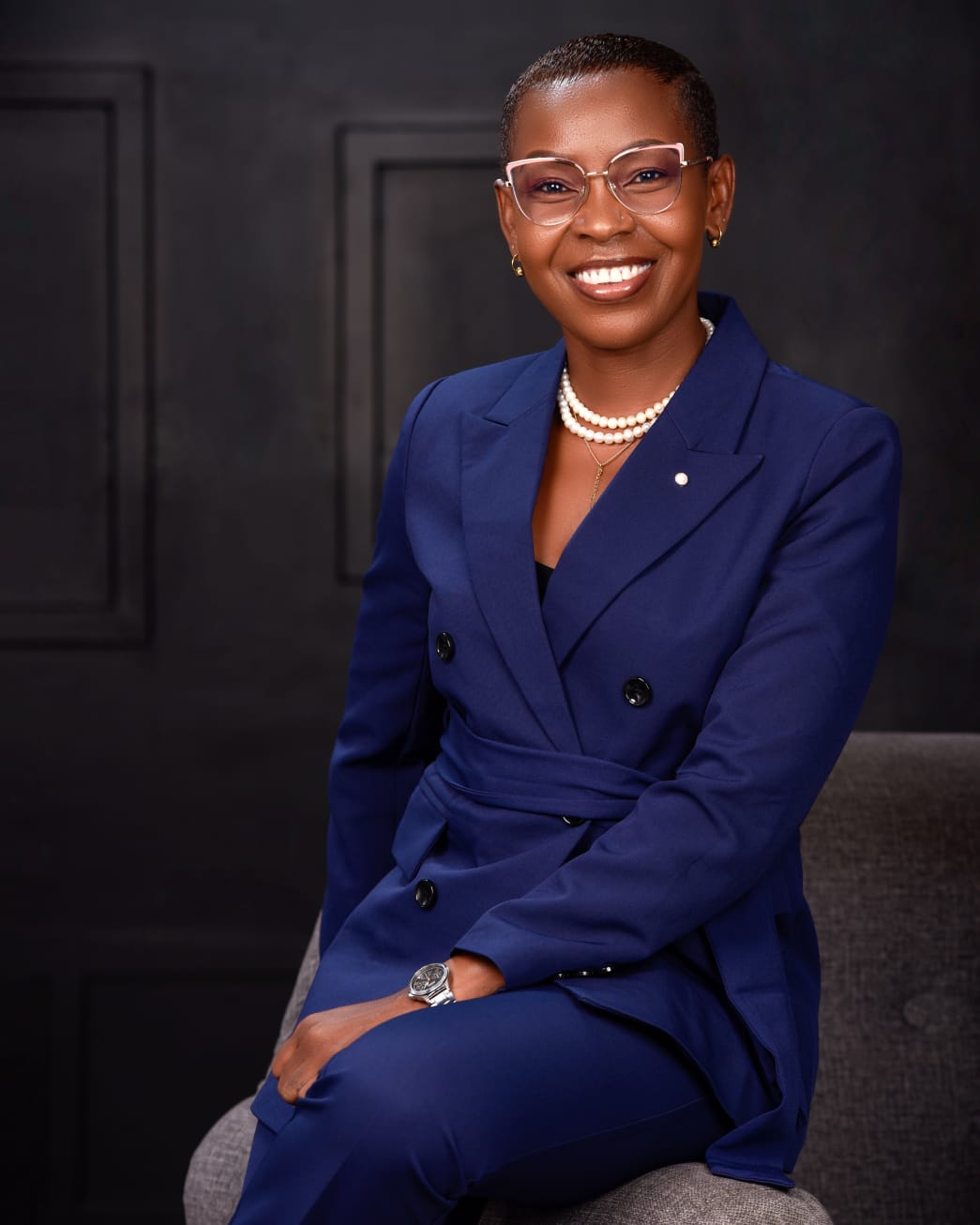 Eunice Ireri in a blue suit, seated portrait