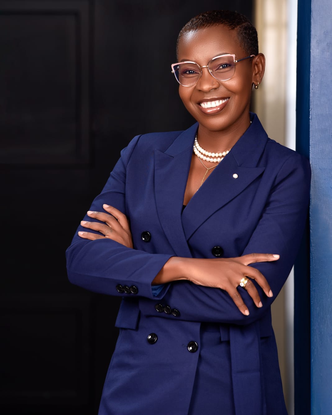Eunice Ireri in a blue suit, seated portrait